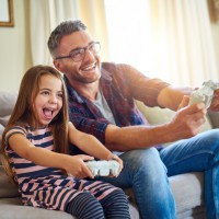 Far och dotter spelar spel tillsammans